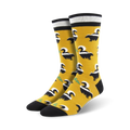 Pair of mustard yellow crew socks with a black skunk pattern.  Features black and white stripes at the top.