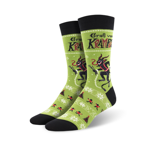 A pair of crew socks in green and black, showcasing a playful Krampus design alongside a festive winter pattern. 