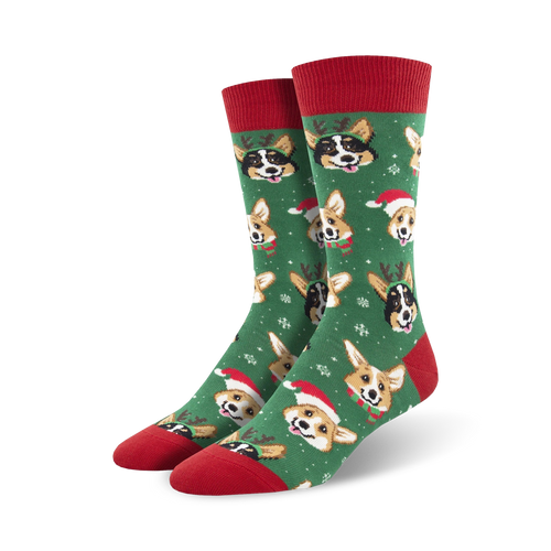 Green crew socks with a festive design. Features adorable Corgi dogs wearing Santa hats and reindeer antlers against a snowflake background.