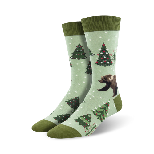Pair of crew socks; light green background, dark green cuffs; features decorated Christmas trees and a brown bear.