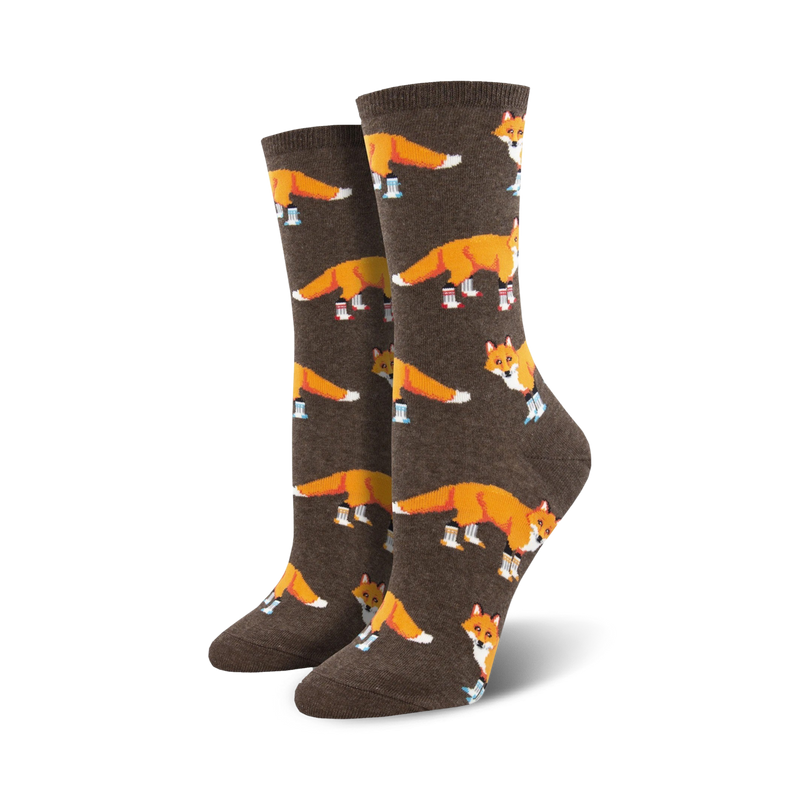 Pair of women's crew socks. Brown background with orange foxes wearing blue boots.  Fun, whimsical design.