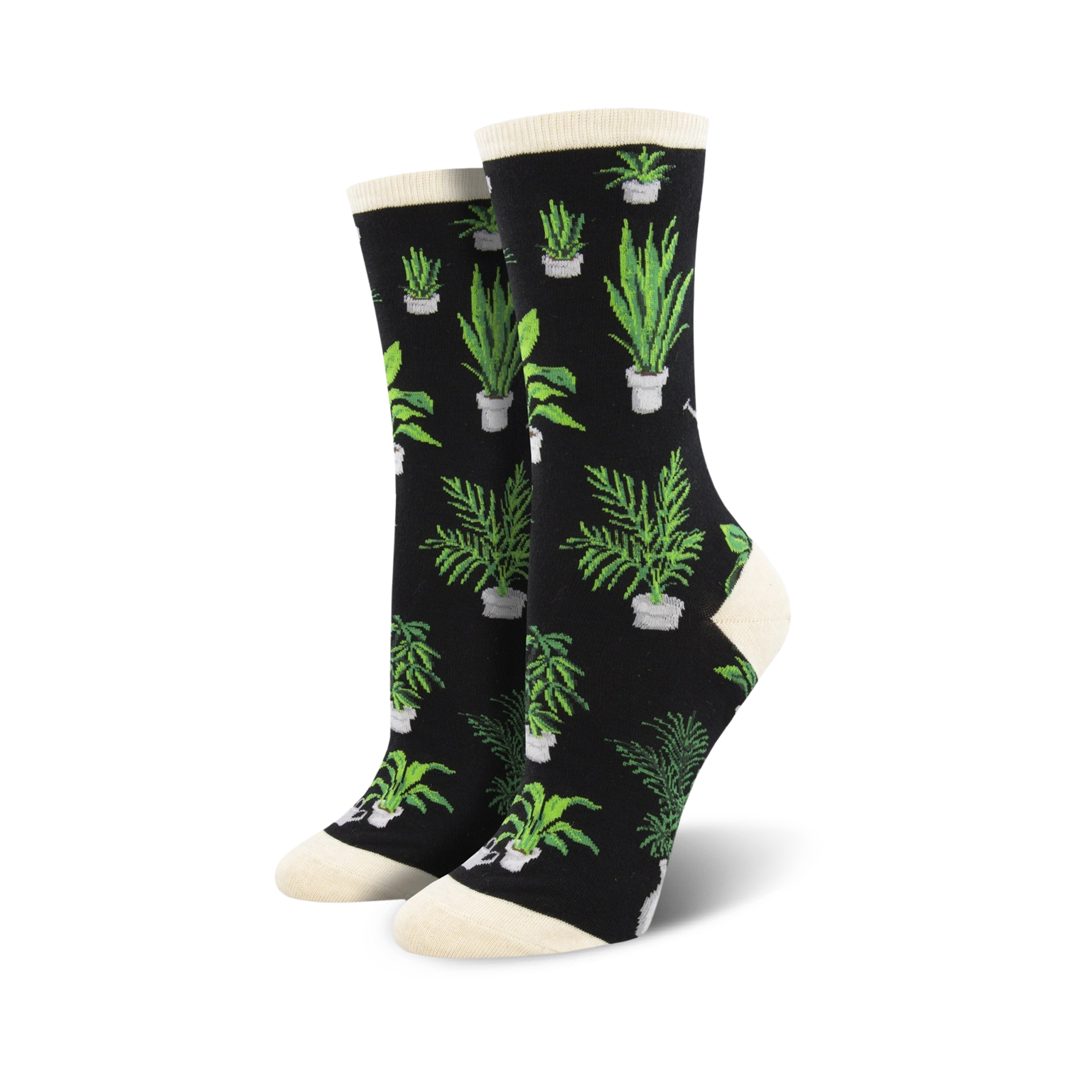 Lifestyle shot of woman wearing the cream Home Grown socks with brown clogs in a garden setting.