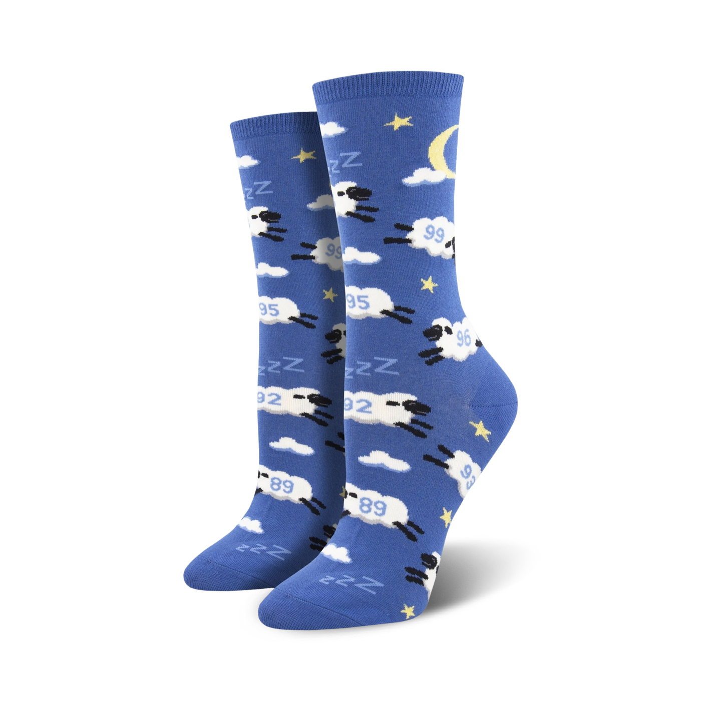 Pair of crew socks in blue with white clouds, stars, a crescent moon, and black sheep jumping.  The sheep have 'Zzz' above them.