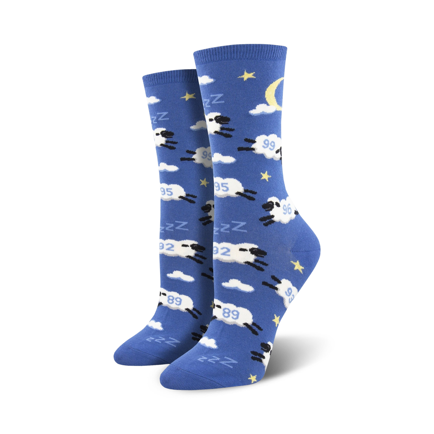 Pair of crew socks in blue with white clouds, stars, a crescent moon, and black sheep jumping.  The sheep have 'Zzz' above them.
