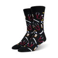 A pair of black crew socks with a fun pattern. The design includes red stethoscopes, syringes, and pills on a black background.