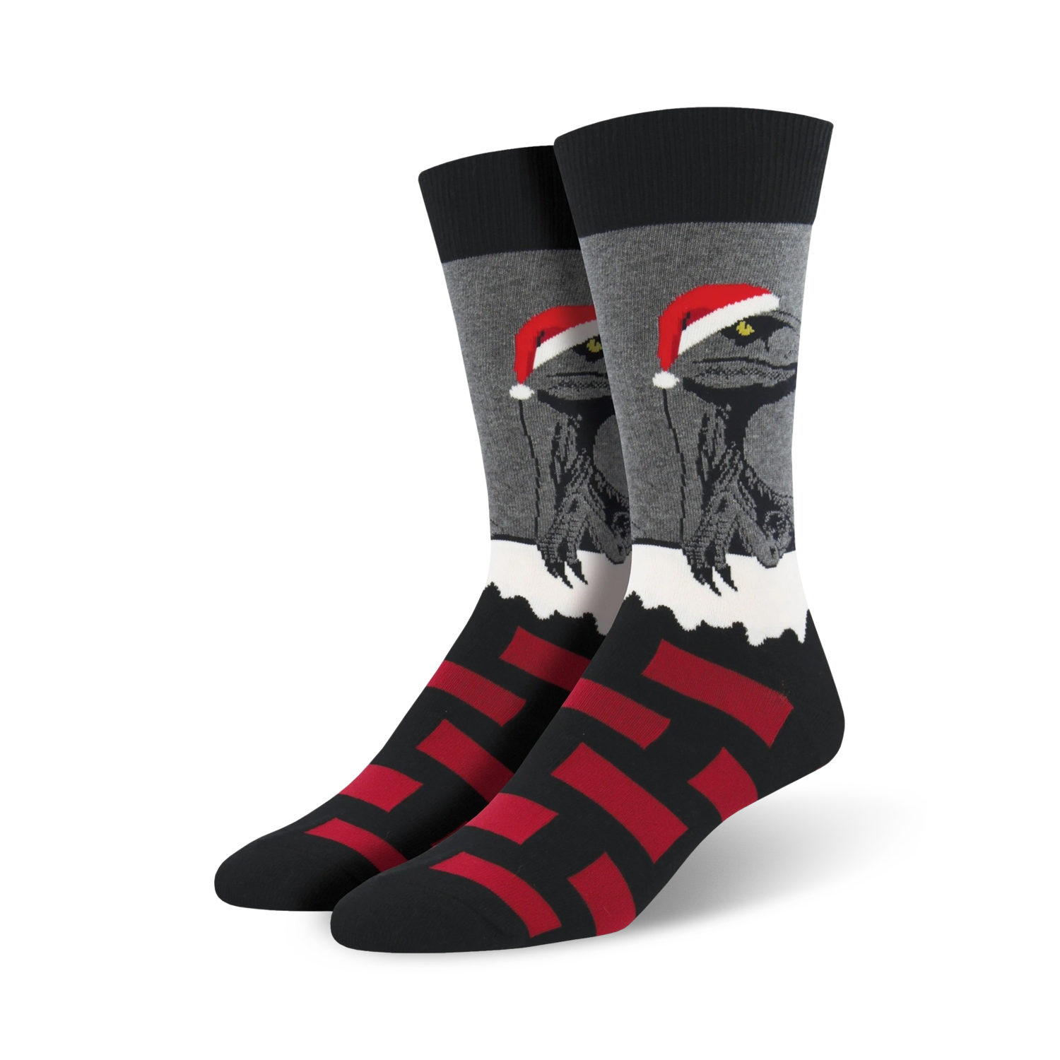 A pair of black, gray, and red crew socks. The main design is a velociraptor wearing a Santa hat, set against a snowy background. Red block pattern at the bottom.