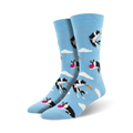 A pair of crew socks in light blue.  The design features black and white border collies catching pink frisbees against a cloudy sky.
