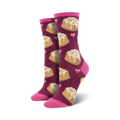 Lifestyle shot showing the Lovely Buns socks in burgundy with cinnamon rolls and pink hearts on a woman's feet.