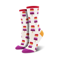 Pair of crew socks with a white background and repeating pattern of lesbian flag-colored popsicles.  Red, orange, purple, and white popsicle design; purple and orange heel and toe.