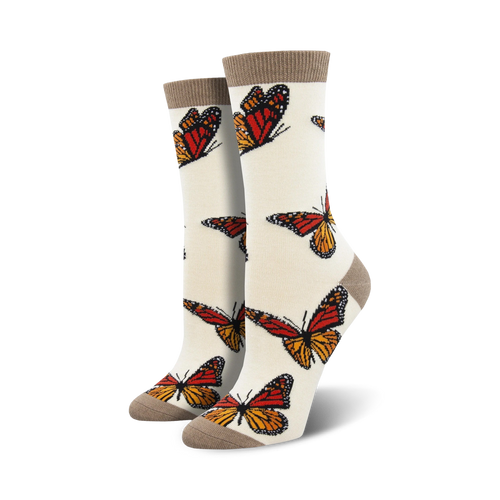 Pair of cream women's crew socks adorned with orange and brown monarch butterfly prints.  Features a subtle taupe cuff.