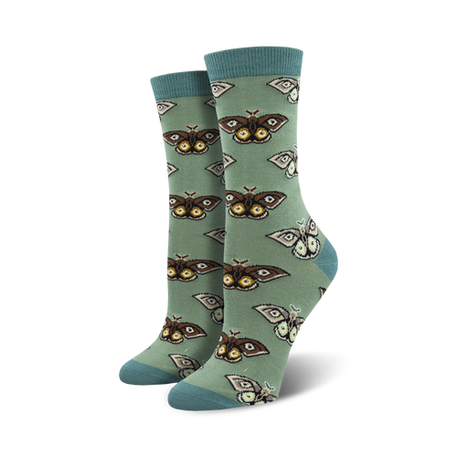 Close-up of a pair of sage green crew socks with a repeating pattern of brown and cream moths. Soft bamboo fabric.