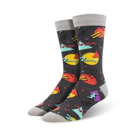 dark gray socks with colorful geometric shapes (triangles, squares, circles) in red, yellow, blue, and green inspired by 90s fashion. (crew).   