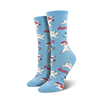 A pair of women's crew socks in light blue. The socks are covered in a pattern of polar bears wearing red scarves, penguins, and Coca-Cola logos.