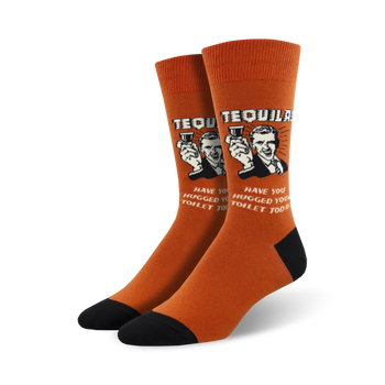A pair of orange crew socks with a retro-style graphic of a man holding tequila shots and the text, 'Have you hugged your toilet today?'