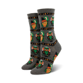 Pair of crew socks in grey and orange, showcasing a repeating pattern of pixel art witches and owls with stars and crescent moons.