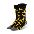 Pair of black crew socks with a fun pattern of yellow dinosaur nuggets.  Comfortable and playful!