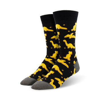 Pair of black crew socks with a fun pattern of yellow dinosaur nuggets.  Comfortable and playful!
