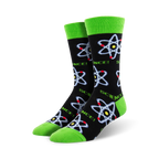 A pair of crew socks with a black background, lime green cuffs, and repeating atom designs in blue, red, and yellow.
