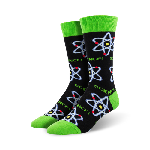 A pair of crew socks with a black background, lime green cuffs, and repeating atom designs in blue, red, and yellow.
