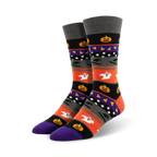 A pair of crew socks with a Halloween theme. The design includes orange, purple, black, and grey stripes with pumpkins, ghosts, and witches' hats.