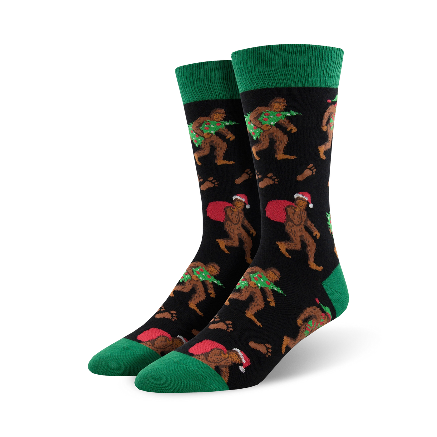 Pair of crew socks; black background with Bigfoot carrying a Christmas tree and Santa sack; green cuffs; red and green accents.