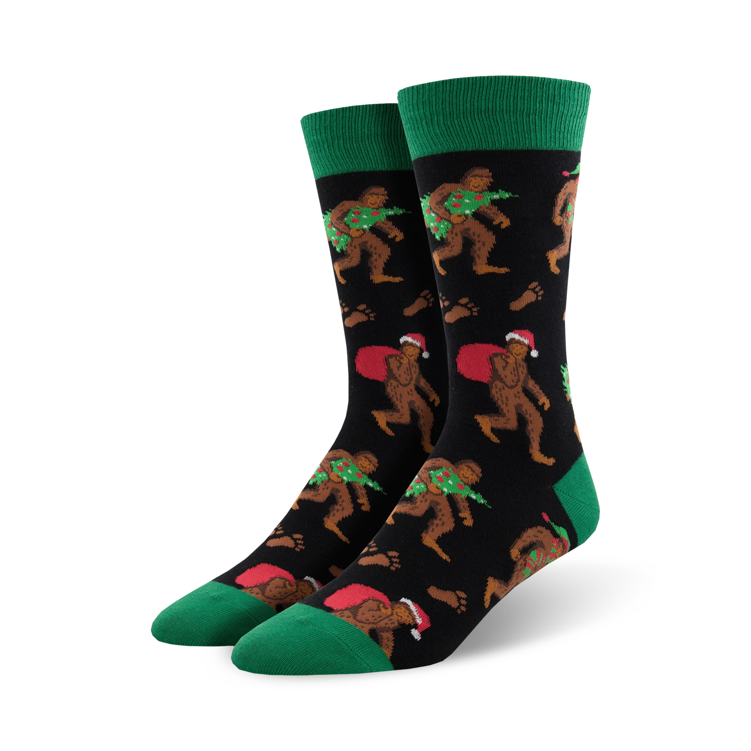 Pair of crew socks; black background with Bigfoot carrying a Christmas tree and Santa sack; green cuffs; red and green accents.