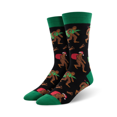 mens crew socks with christmas bigfoot pattern, santa hat, presents, wreath, black, green.    