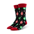 Pair of crew socks with a black background, red and green Christmas ornaments, and snowflakes. Red cuffs.