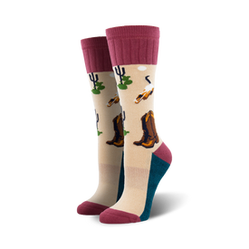 beige boot socks with pink ribbed cuff feature pattern of cowboy boots, cacti, and skulls.  