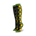 Pair of black knee-high socks with a vertical pattern of yellow dandelions and green leaves.