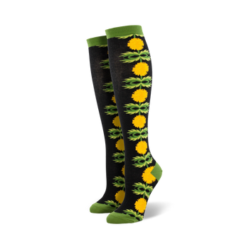 Pair of black knee-high socks with a vertical pattern of yellow dandelions and green leaves.
