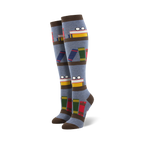 Pair of blue knee-high socks with a bookshelf design. Books, glasses, and brown stripes are featured on a grey-blue background.