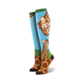Pair of knee-high socks; light blue background, brown giraffes, green accents. Adult sized.