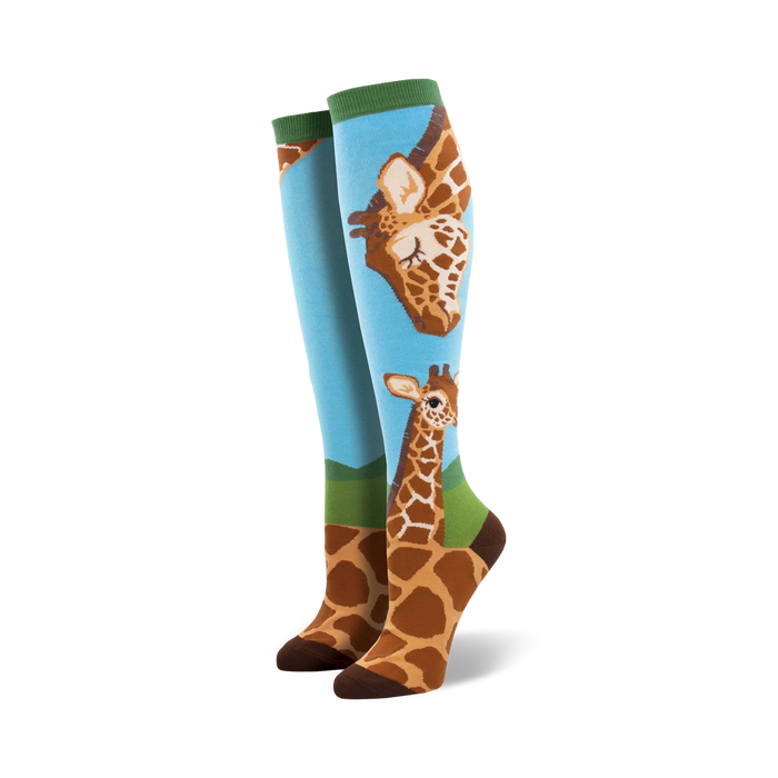 loving giraffes knee-high socks: charming blue background, green cuff, cute brown giraffe pattern, one large facing left, one smaller facing right, perfect for women's casual wear.   