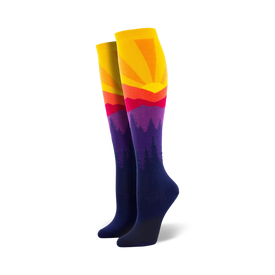 women's knee-high mountain sun socks with purple, blue, orange, and yellow pattern of pine trees and a setting sun.  