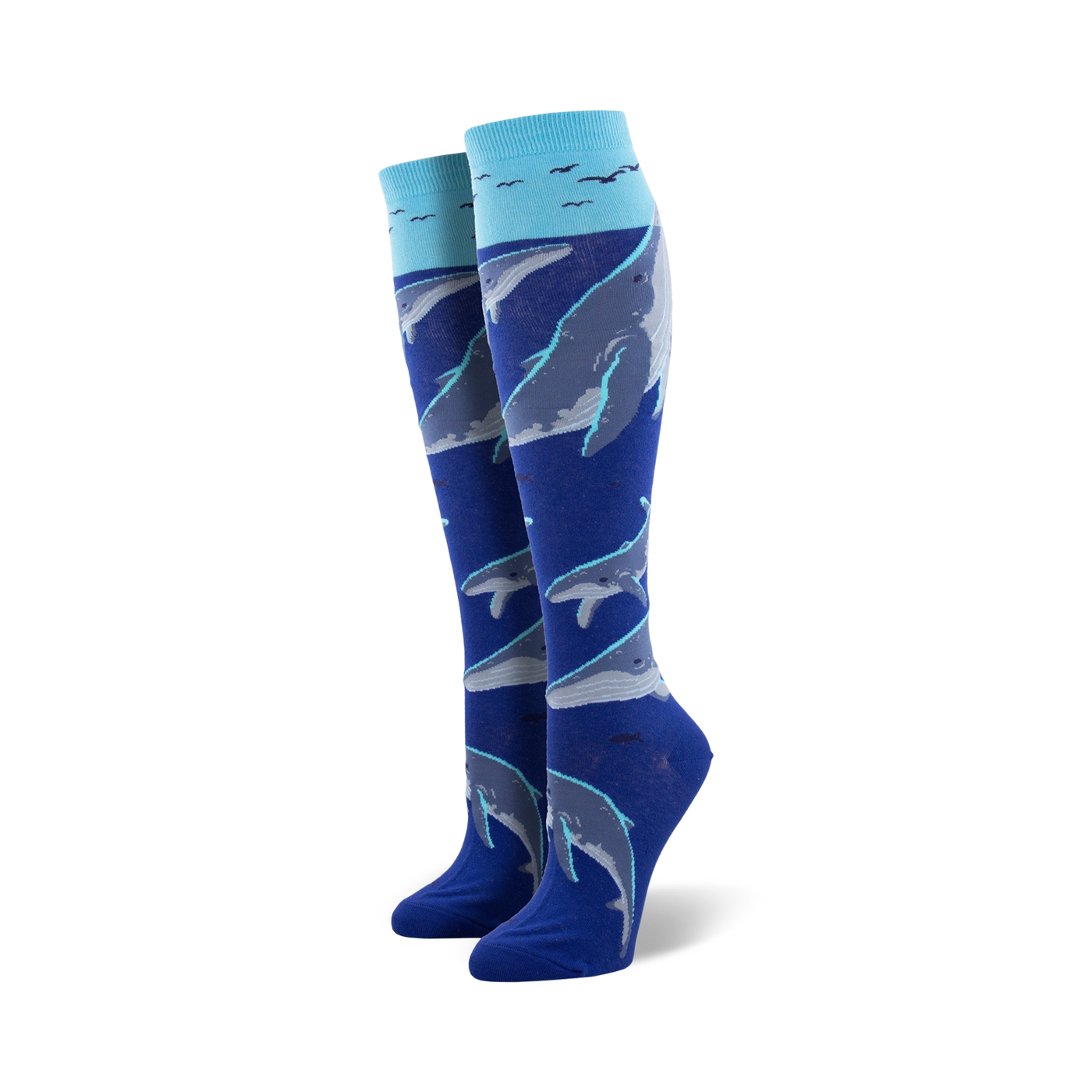 Pair of women's knee-high socks in blue and teal, adorned with a pattern of whales swimming underwater, accented with small birds near the top.