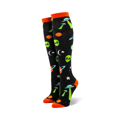 black womens knee high novelty socks feature green aliens, orange crescent moons, stars, planets, and flying saucers.    