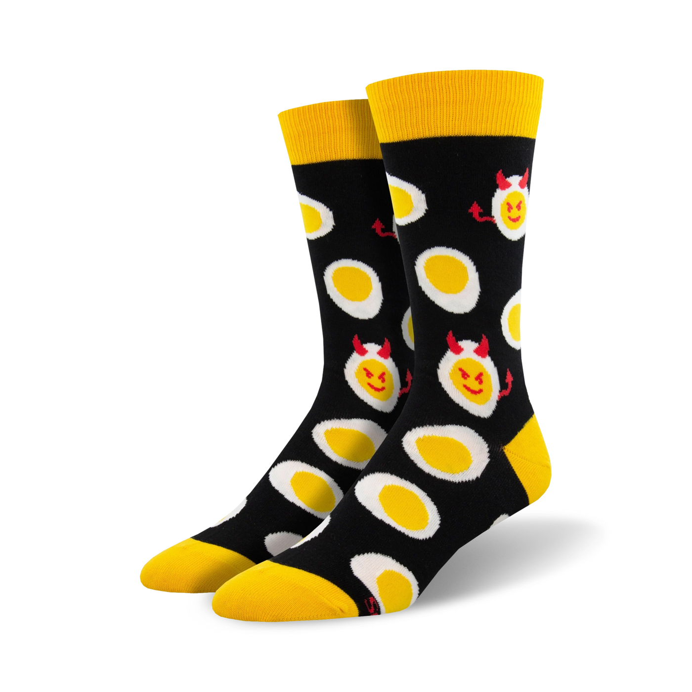 A pair of black crew socks with a fun pattern of yellow deviled eggs. The eggs have small red devil horns and mischievous smiles.