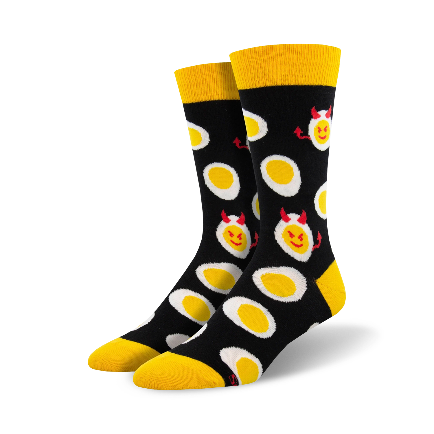 A pair of black crew socks with a fun pattern of yellow deviled eggs. The eggs have small red devil horns and mischievous smiles.