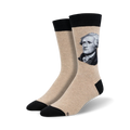 A pair of beige crew socks with a black cuff, featuring a grayscale portrait of Alexander Hamilton.