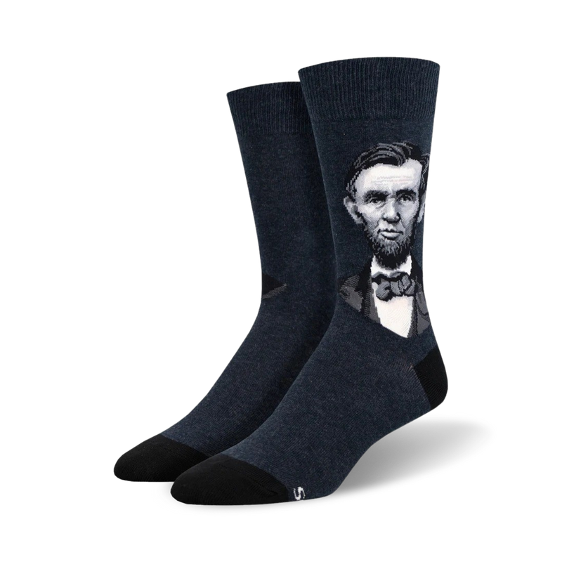 Pair of dark navy blue crew socks with a grayscale portrait of Abraham Lincoln.  The socks have black soles.