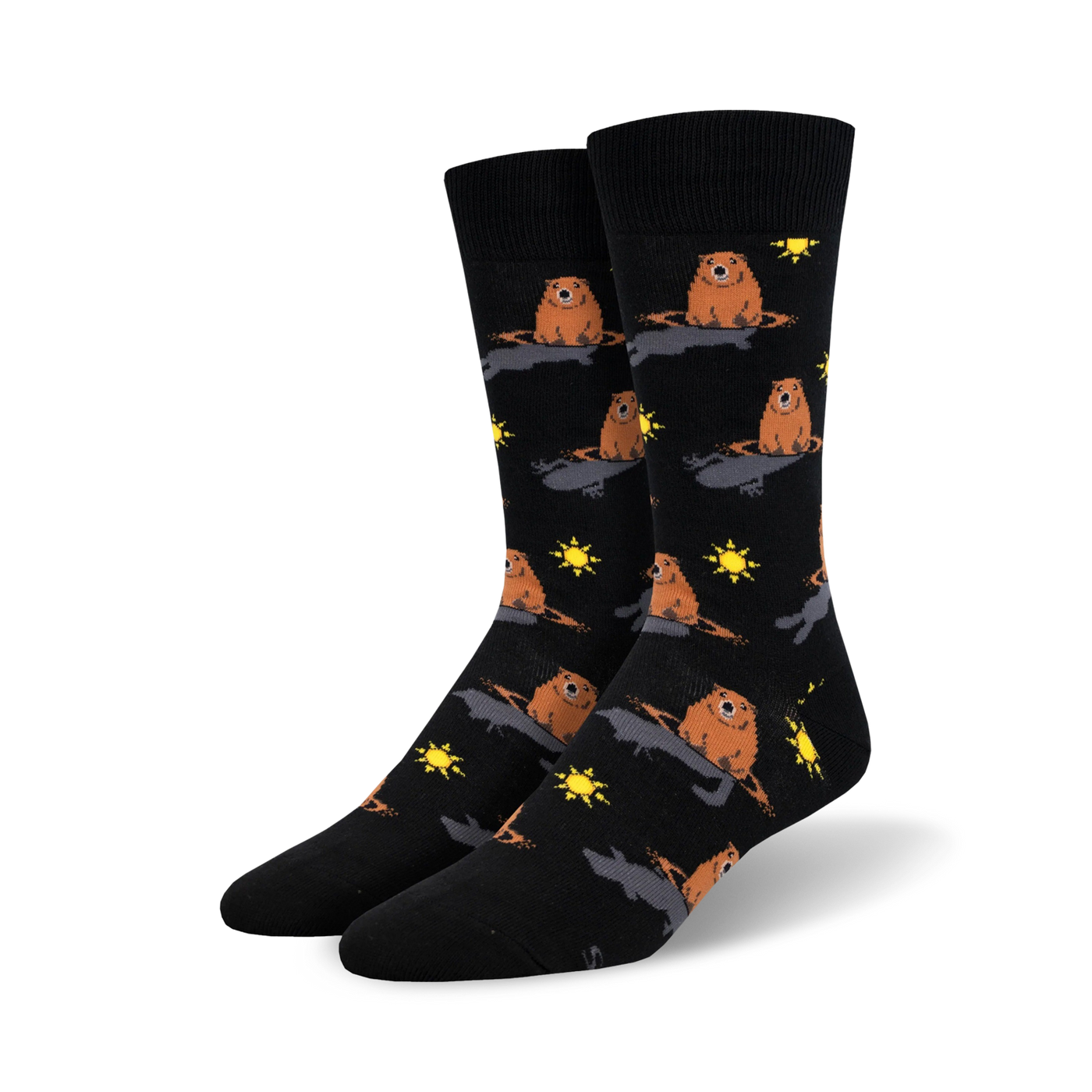 A pair of black crew socks with a repeating pattern of brown groundhogs emerging from holes, accented with yellow suns.