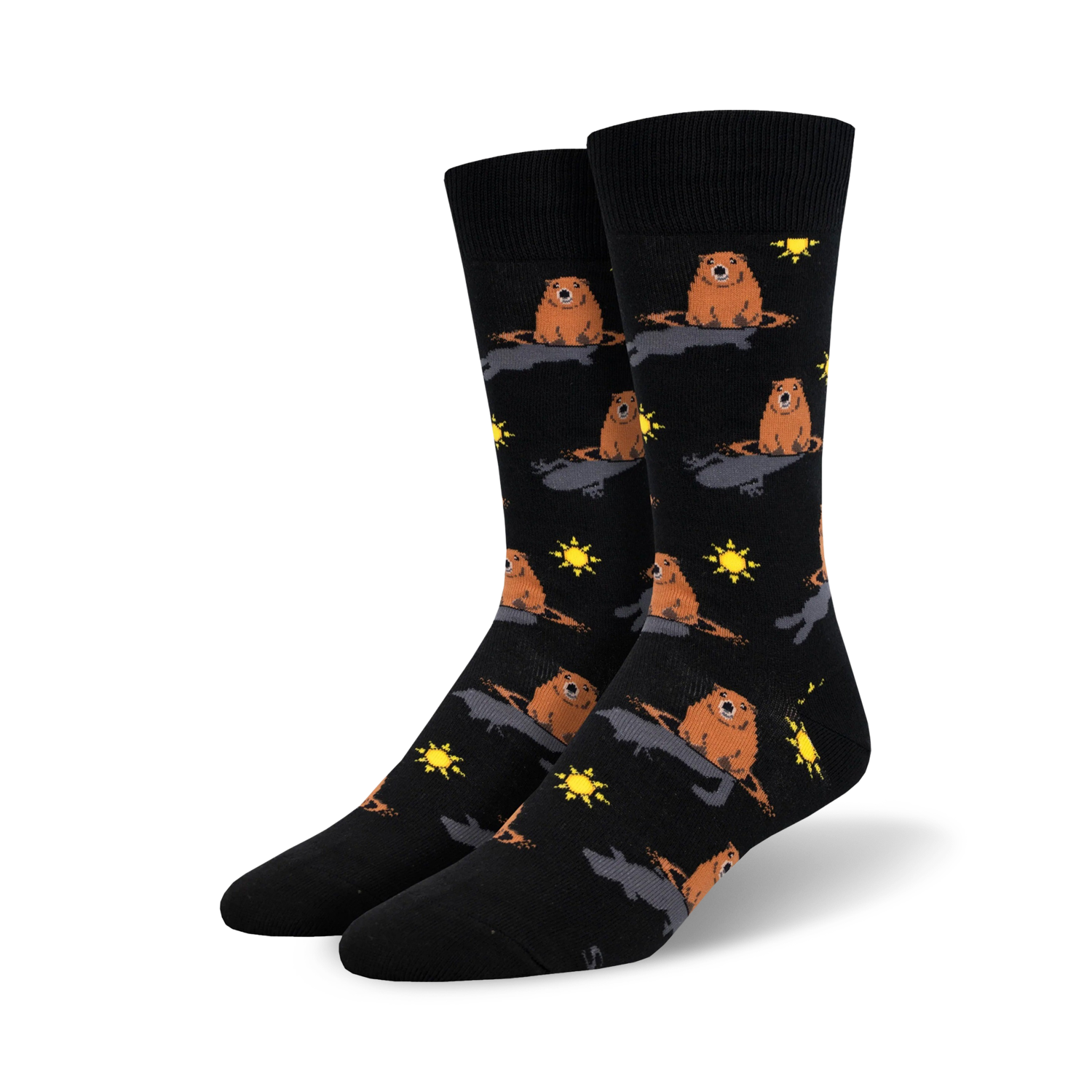 A pair of black crew socks with a repeating pattern of brown groundhogs emerging from holes, accented with yellow suns.