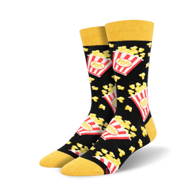 black popcorn socks with "pop!" written on red and white popcorn boxes, loose popcorn scattered about, yellow top. crew length, men's sizing.   