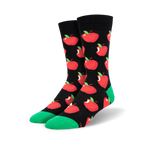 A pair of crew socks with a black background and a repeating pattern of red apples with green stems. The socks have a bright green cuff.