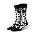 Pair of black and white crew socks featuring a crossword puzzle design. Numbers are visible in the grid.