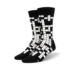 Pair of black and white crew socks featuring a crossword puzzle design. Numbers are visible in the grid.