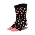 Pair of crew socks with a black background, adorned with red and white candy canes and green and red peppermint swirls.