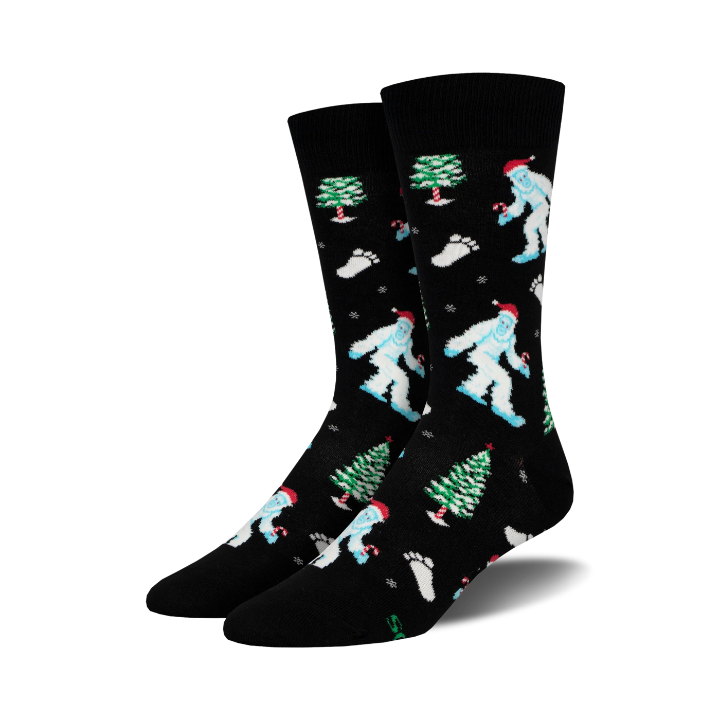 A pair of black crew socks with a whimsical Christmas design.  Features light blue Yetis in Santa hats, green Christmas trees, and candy canes.