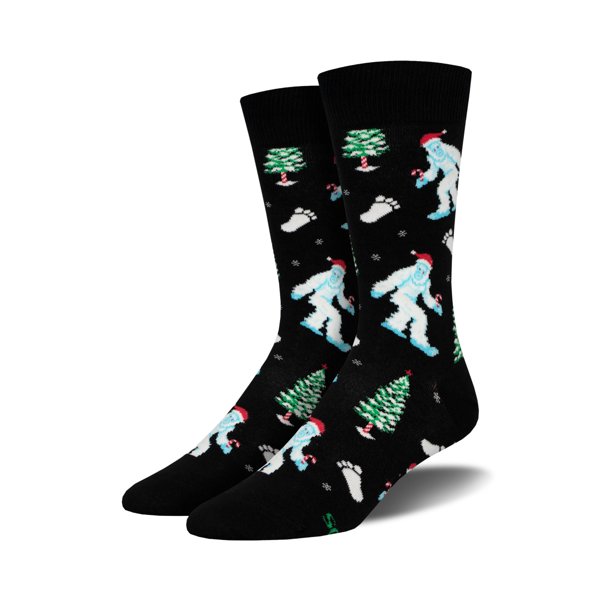 A pair of black crew socks with a whimsical Christmas design.  Features light blue Yetis in Santa hats, green Christmas trees, and candy canes.